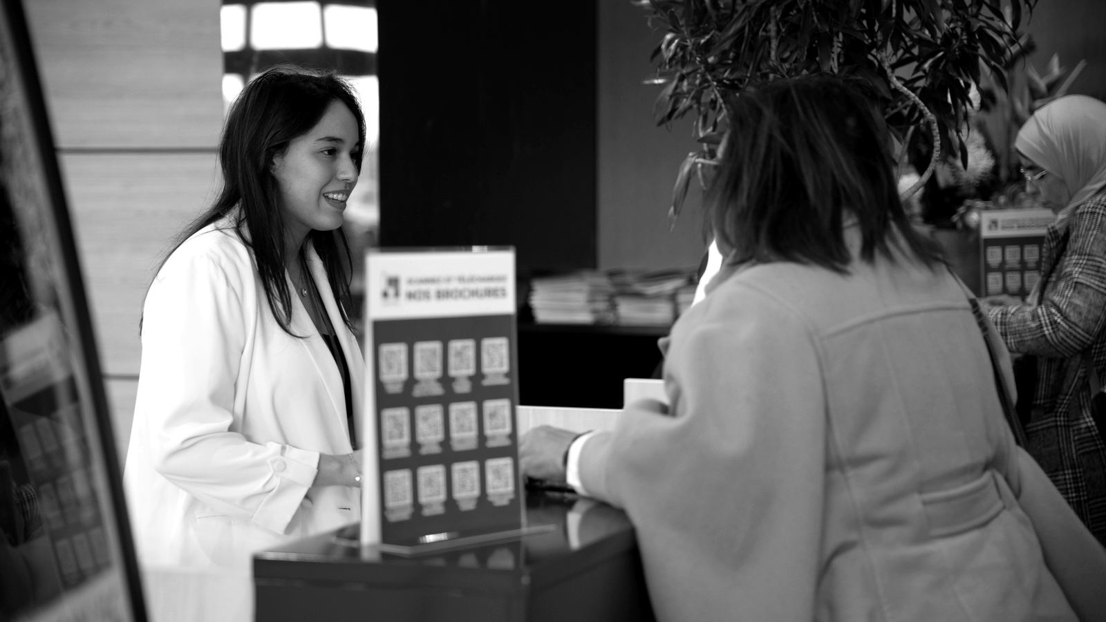 A staff member greeting a visitor at the registration desk